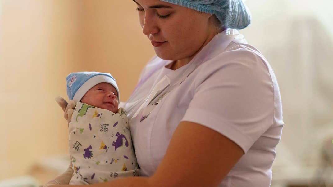 Врач-интерн держит девочку, которая родилась преждевременно на 29 неделе в Покровском перинатальном центре, 15 августа 2022 года