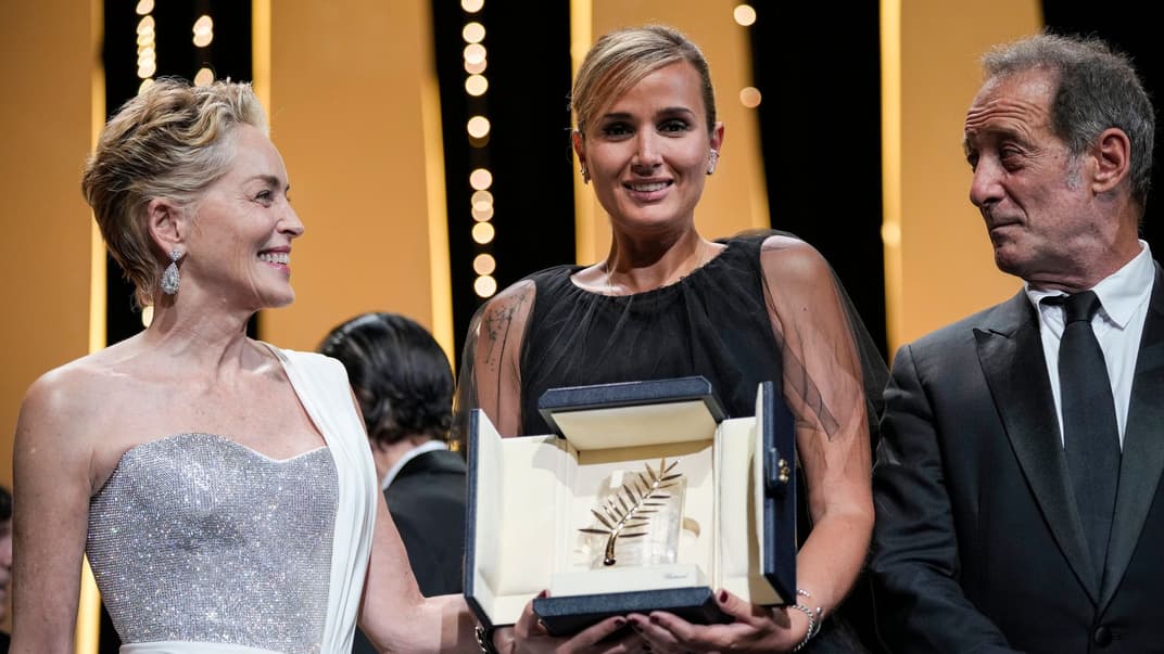 Режисерка фільму «Титан» Джулія Дюкроно (в центрі) під час отримання «Золотої пальмової гілки» разом із Шерон Стоун (зліва) і Вінсентом Ліндоном. Канни, Франція, 17 липня 2021 року