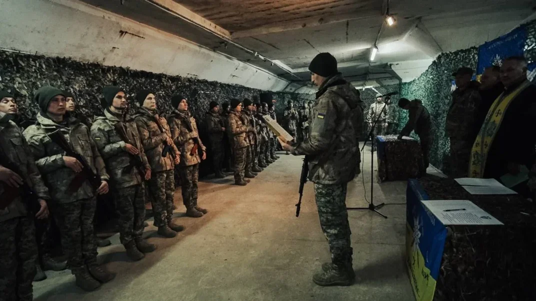 Иллюстративное фото. Молодой доброволец читает текст присяги перед побратимами