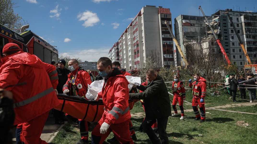 Медики забирають до моргу тіло загиблої людини, щойно знайденої під завалами будинку в Умані, у який влучила російська крилата ракета