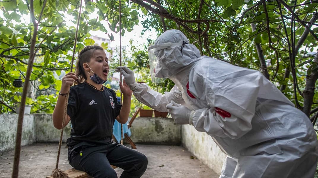 Медичний працівник лікарні «Меморіал», одягнений у повний захисний костюм, бере пробу мазка у дитини під час тестування Covid-19 в Стамбулі, Туреччина, 26 жовтня 2020 року.