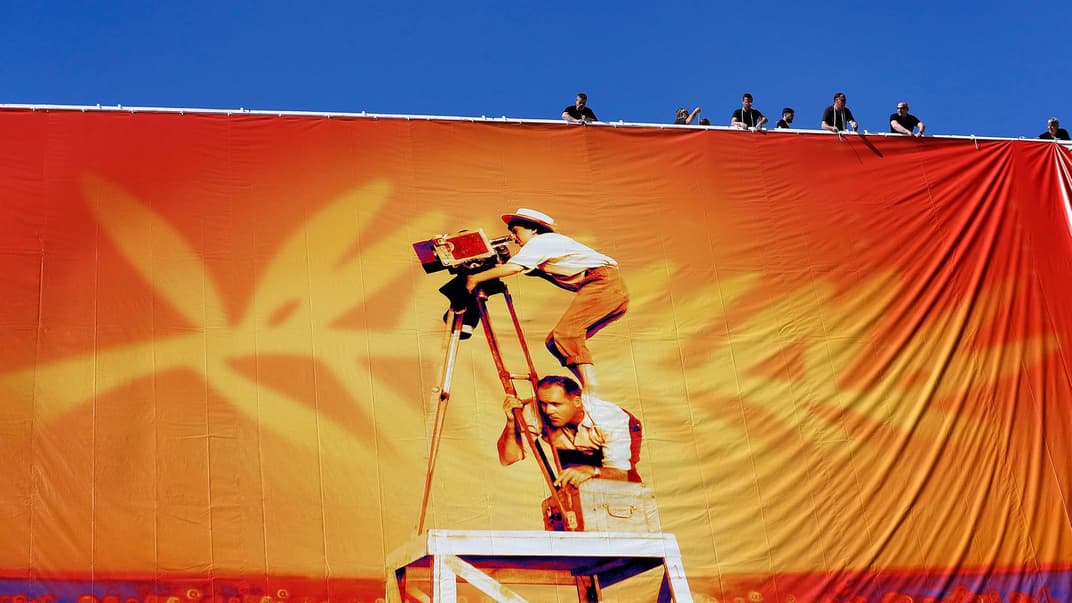 Робітники вішають офіційний плакат 72-го щорічного Каннського кінофестивалю на фасаді Палацу фестивалів у Каннах, Франція, 12 травня 2019 року