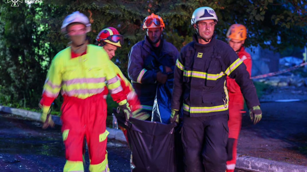 Рятувальники несуть тіло загиблої дівчини, деблоковане з-під завалів у Луцьку