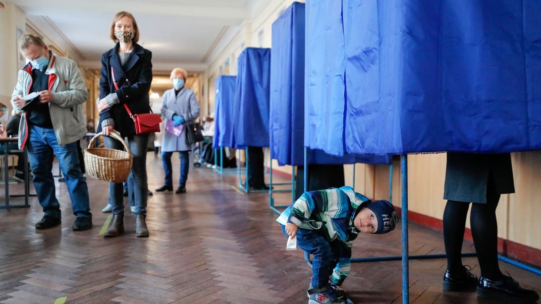 Хлопчик чекає, коли його мати проголосує під час місцевих виборів у Києві, Україна, 25 жовтня 2020 року.