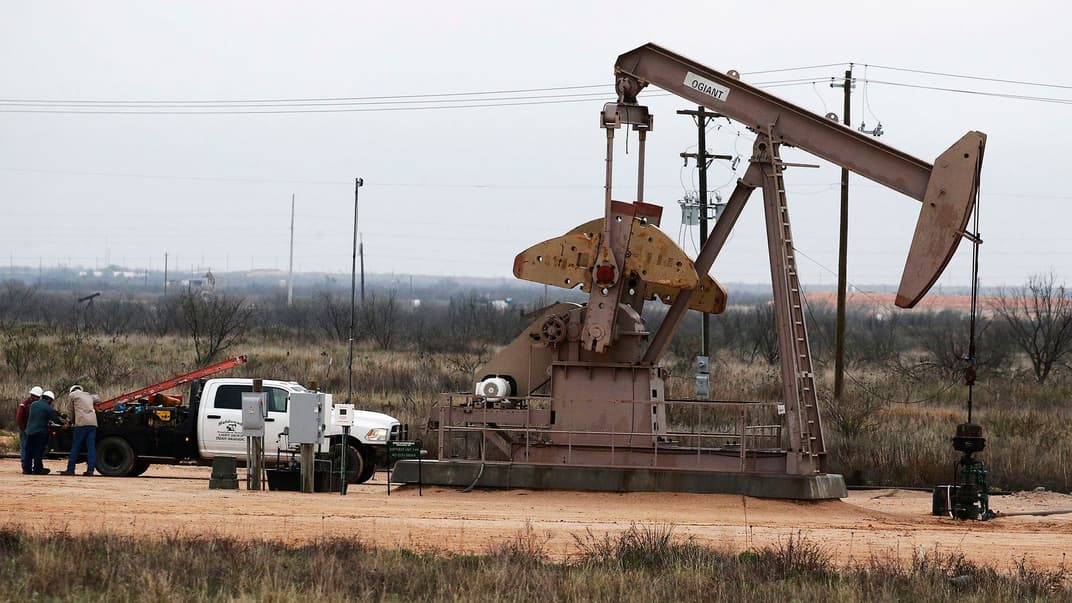 Работники возле насоса на нефтяном месторождении вблизи Мидленда в штате Техас, США, 6 апреля 2020 года