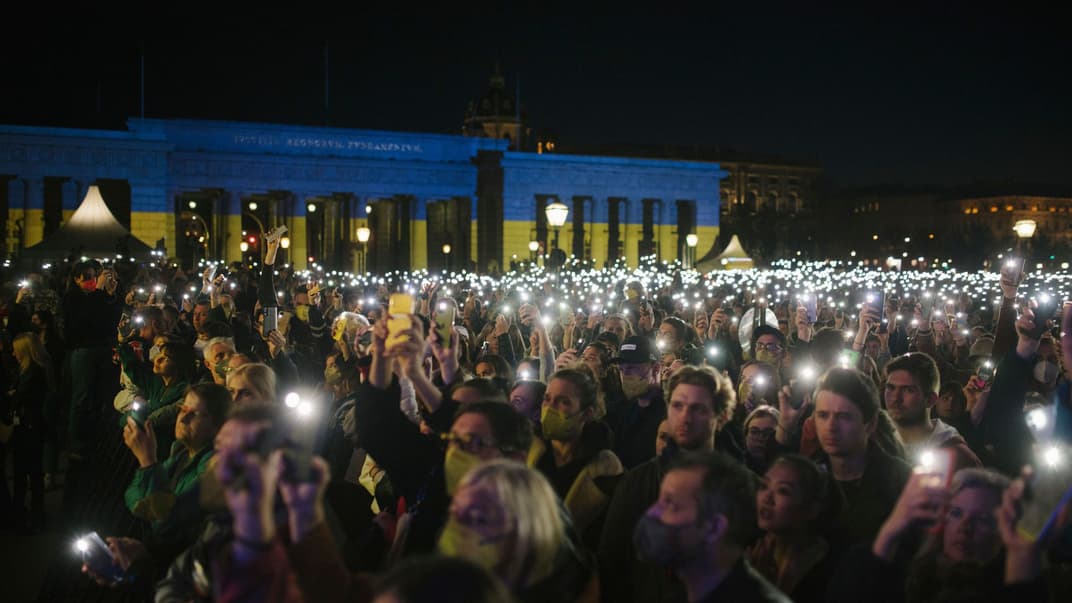 Люди тримають смартфони з ліхтариками під час концерту #YesWeCare на знак протесту проти російського вторгнення в Україну, Відень, 27 березня 2022 року