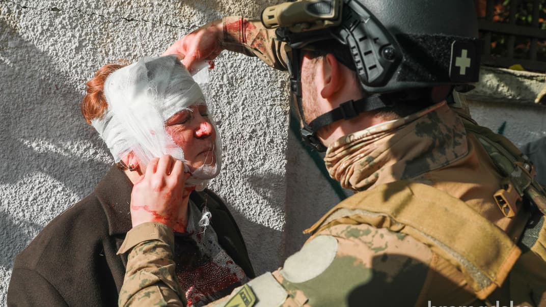 Працівник рятувальної служби робить перев'язку постраждалій від вибухів у Києві, 10 жовтя 2022 року