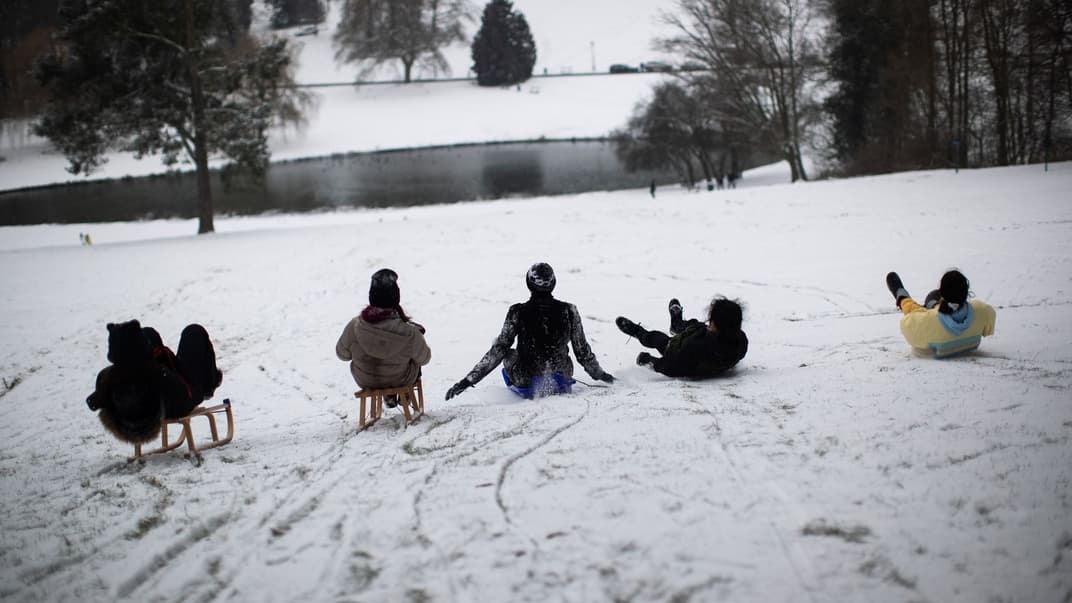 Молодь ковзає з пагорба на санях після снігопаду в парку Волюве в Брюсселі, 8 лютого 2021 року.
