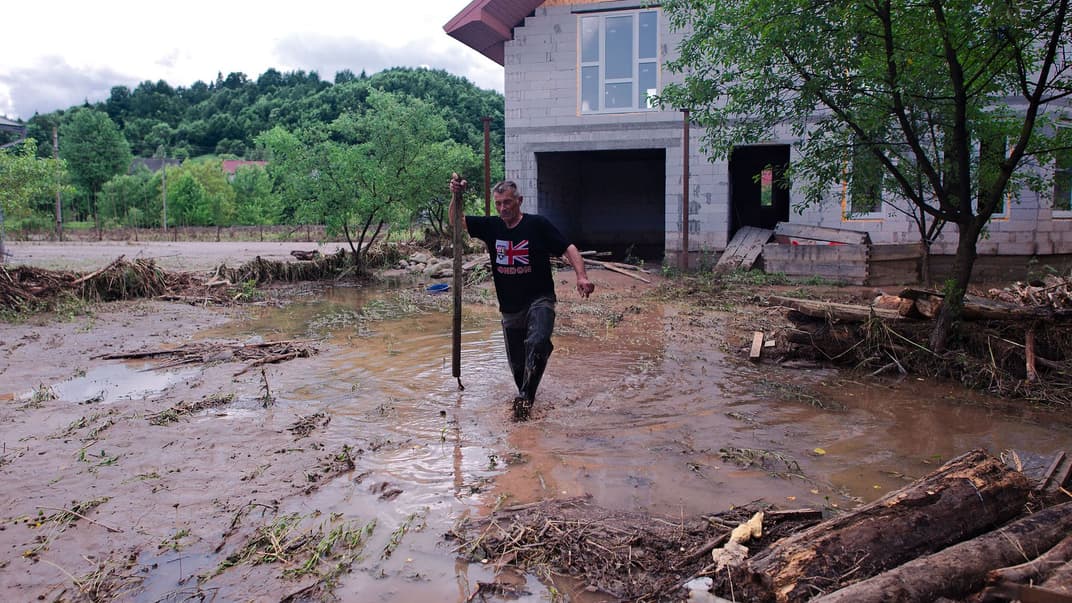 Народні депутати ухвалили закон про виділення грошей з надходження податку на додану вартість до резервного фонду для ліквідації наслідків паводків на заході України. На фото — чоловік виходить через затоплений двір зі свого будинку у Ланчині, Івано-Франківська область, 25 червня 2020 року