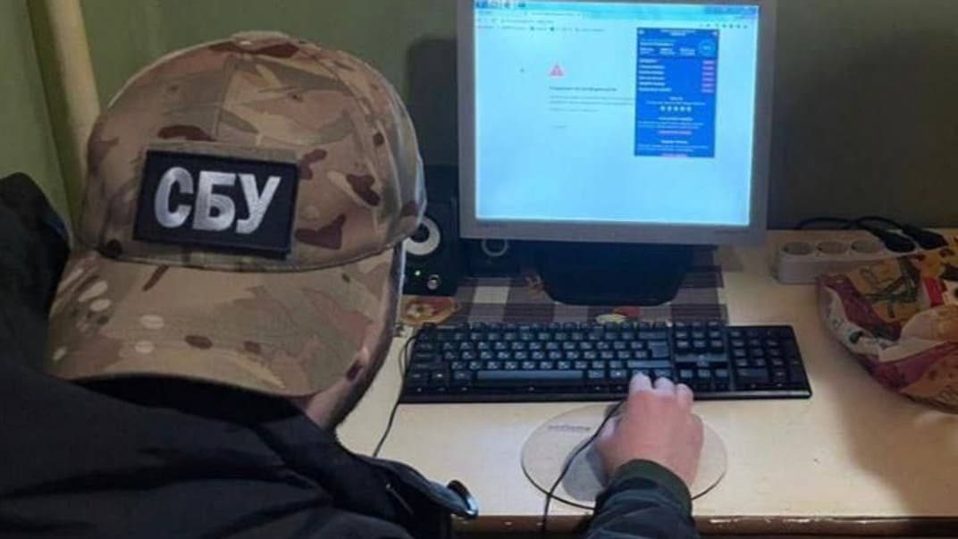 Правоохоронець вивчає комп'ютер підозрюваної мешканки Прикарпаття