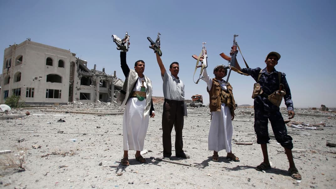 Шиїтські бійці, відомі як хусити, тримають зброю, вигукуючи гасла біля резиденції військового командира групи бойовиків хуситів, знищеної авіаударом під проводом Саудівської Аравії в Сані, Ємен