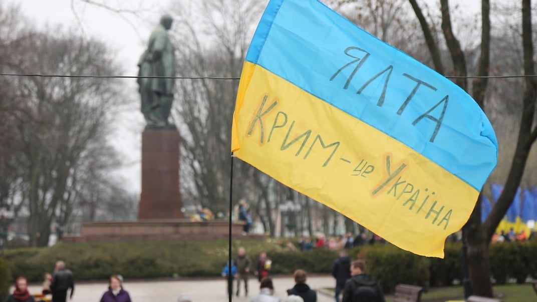 Иллюстративная фотография. Украинское знамя с надписью «Крым — это Украина» во время акции солидарности с украинским Крымом у памятника Тарасу Шевченко в Киеве, 9 марта 2020 года