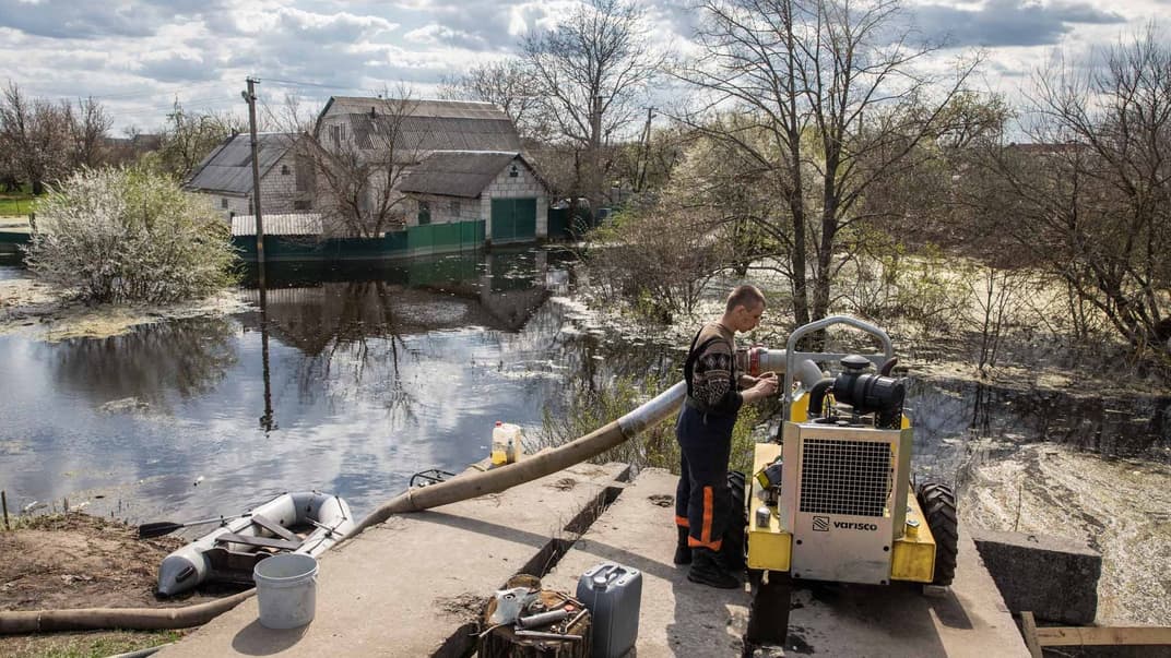 39-річний Олександр стежить за роботою помпи, яка відкачує воду із затопленої частини села Демидів на Київщині