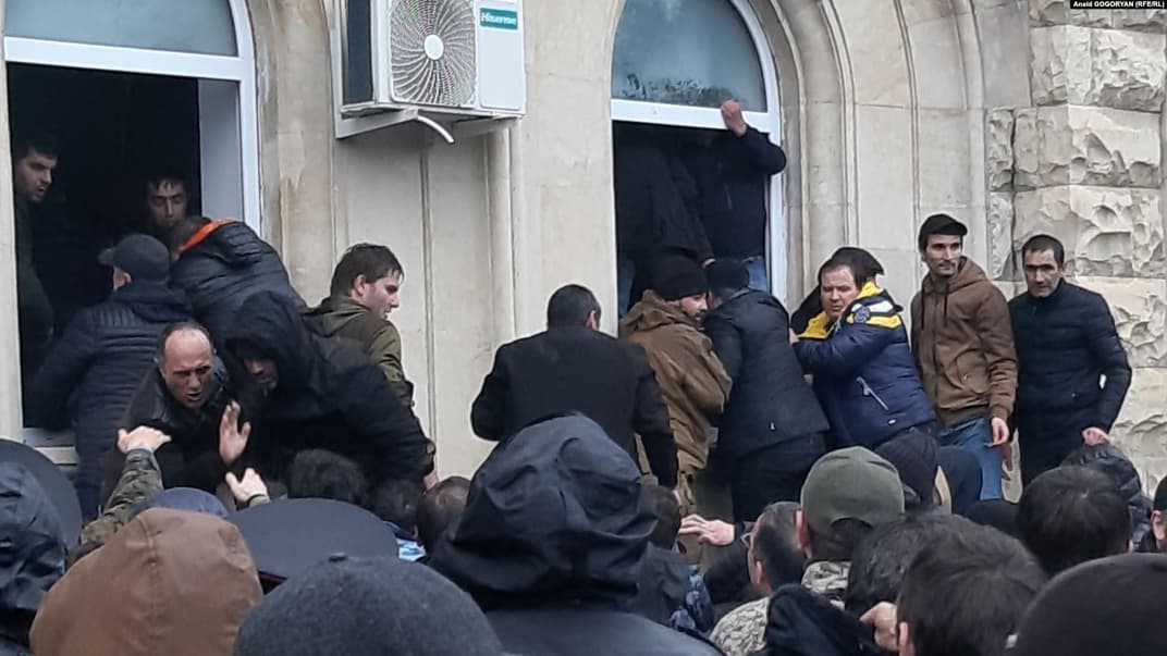 Протестующие захватили здание администрации «президента» самопровозглашенной республики Абхазия, несколько десятков человек зашли внутрь здания через выбитые на первом этаже окна, Сухуми, 9 января 2020 года