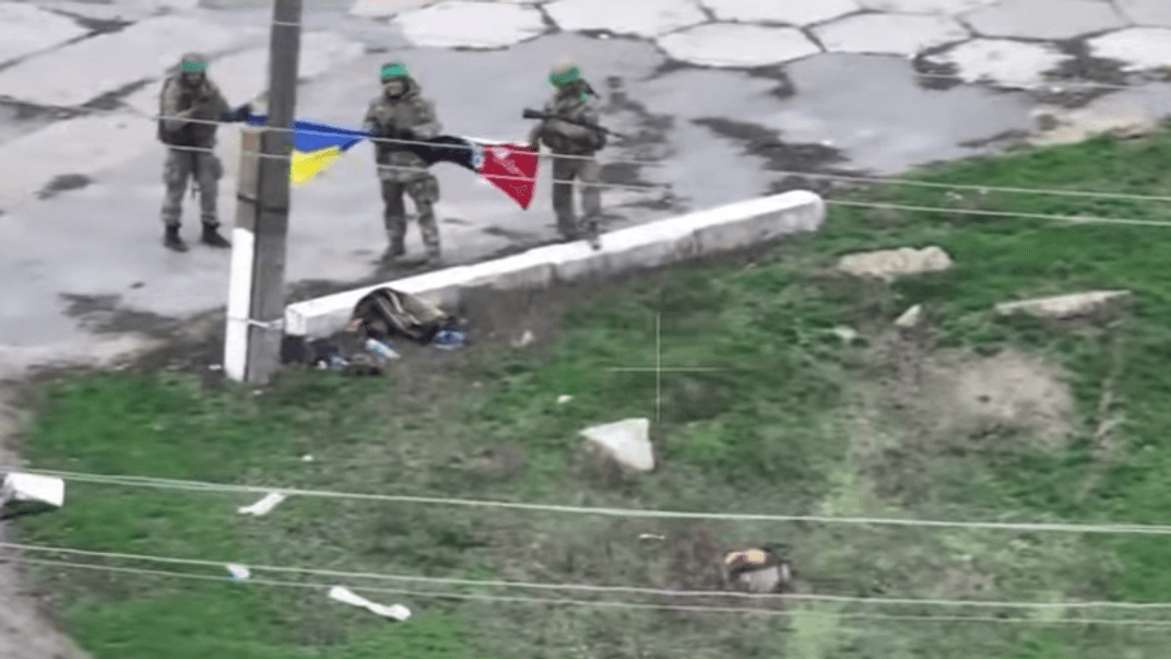 Україснькі військові стоять зі стягами у Тихому