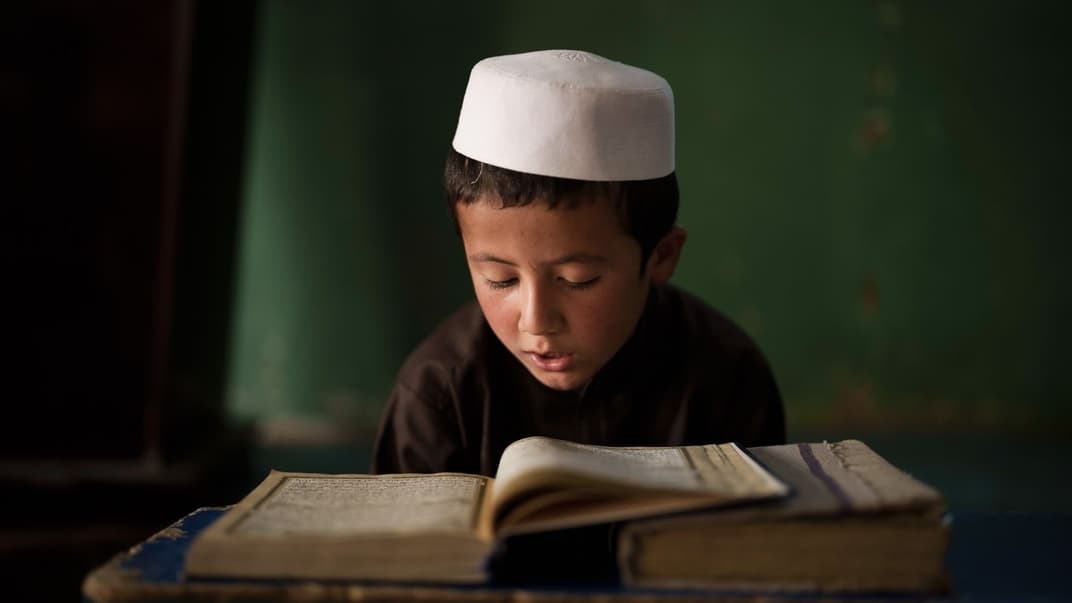 Афганский мальчик читает Коран на уроке в медресе в Кабуле, 28 сентября 2021 года
