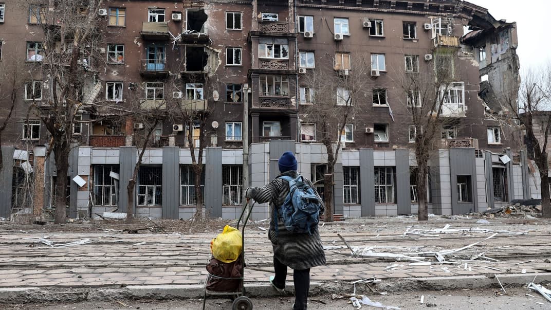 Місцева жителька дивиться на пошкоджений під час важких боїв житловий будинок поблизу металургійного комбінату імені Ілліча, Маріуполь, 16 квітня 2022 року