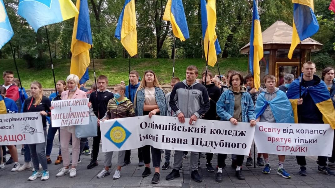Студенты Олимпийского колледжа стоят с плакатами под зданием Кабинета министров, 25 сентября 2020 года