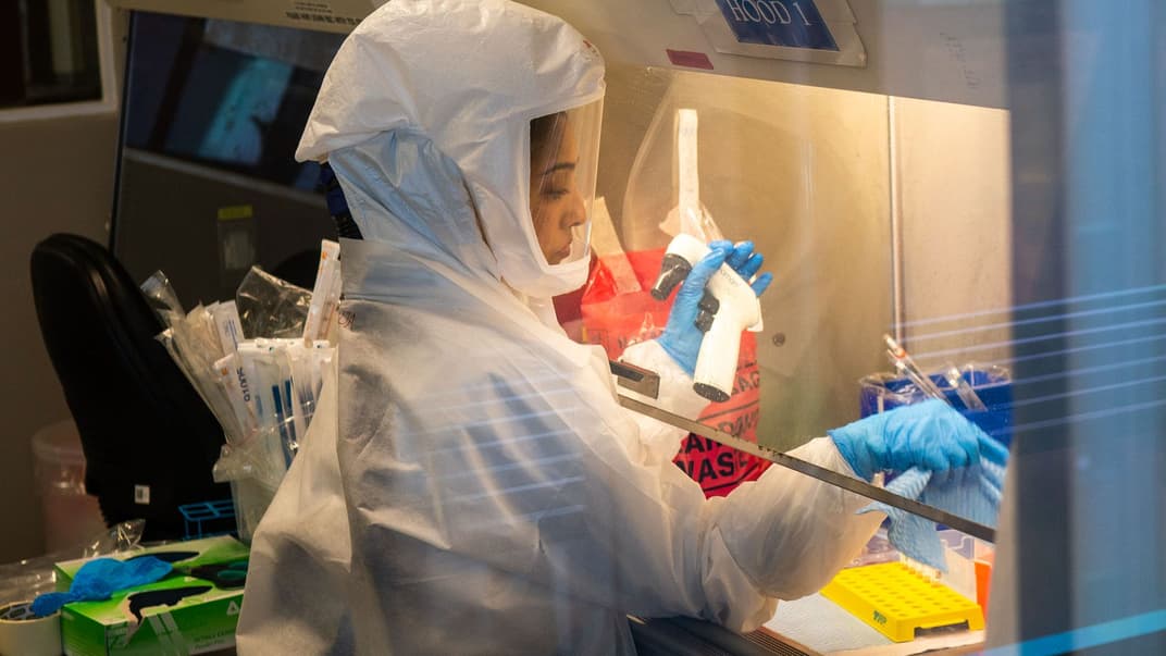 Ученая из Африканского исследовательского института здравоохранения в Дурбане, Южная Африка, исследует штамм коронавируса «Омикрон», 15 декабря 2021 года