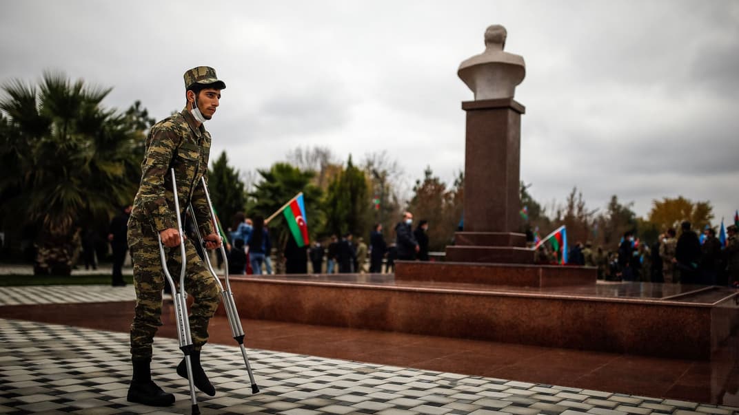 Раненный азербайджанский солдат стоит рядом с бюстом отца президента Азербайджана Ильхама Алиева и бывшего президента Азербайджана Гейдара Алиева, 1 декабря 2020 года