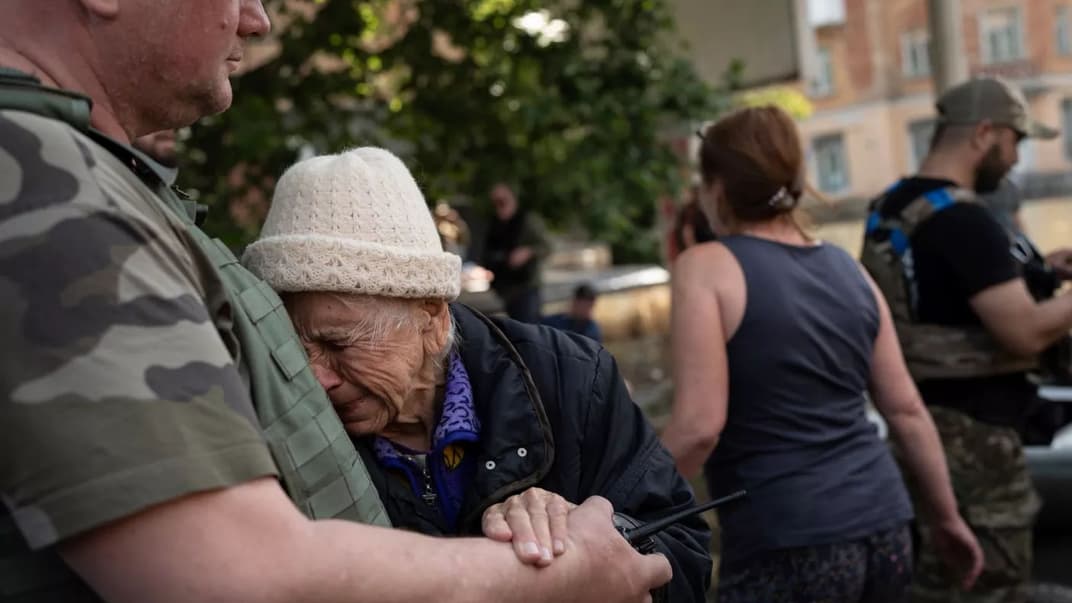 Женщина плачет, когда ее эвакуируют из затопленного района в Херсоне, 7 июня 2023 года