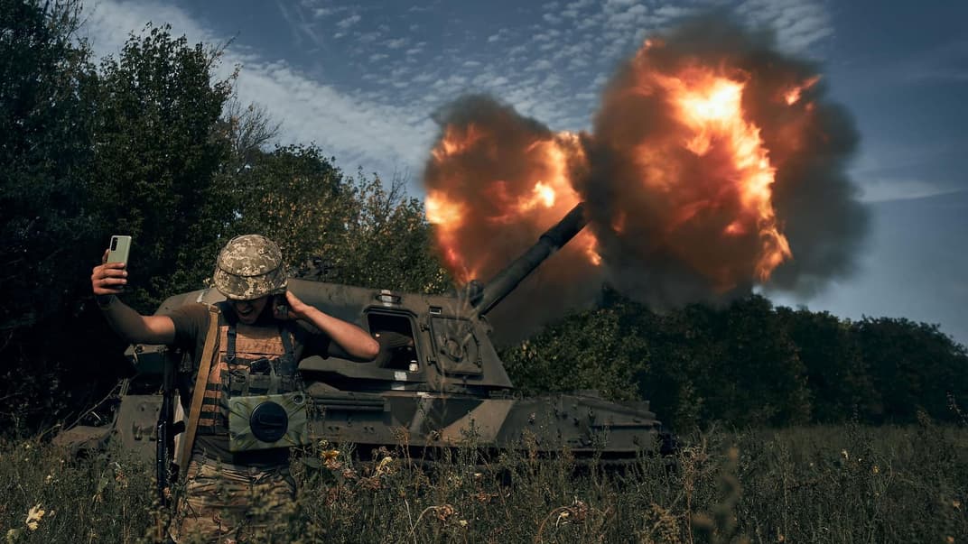 Иллюстративное фото: украинский военный делает селфи на фоне выстрела из артиллерии