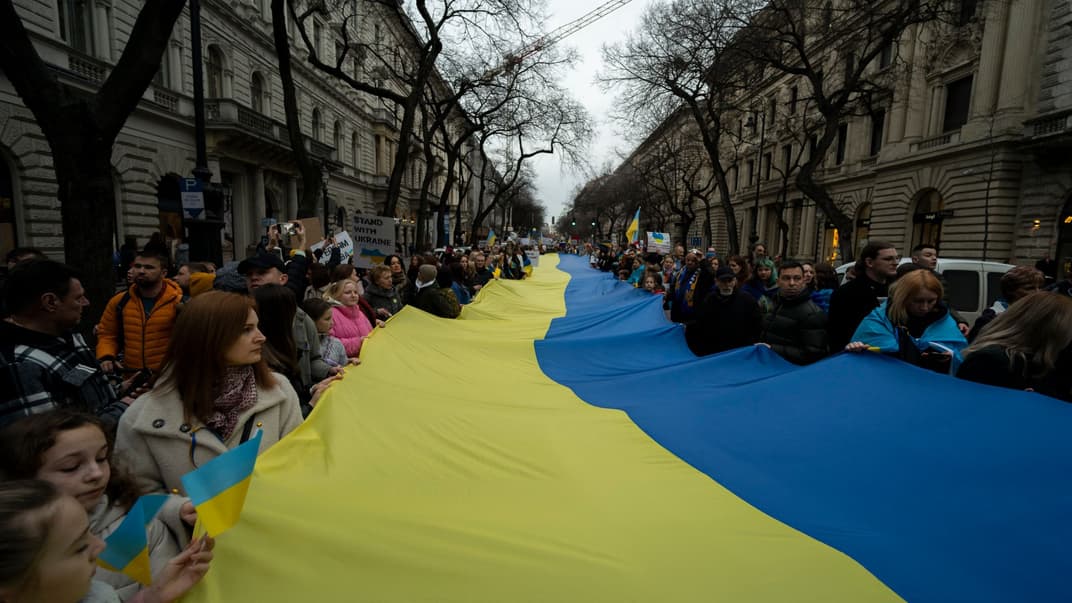 Люди тримають український прапор під час демонстрації в Будапешті, 24 лютого 2024 року