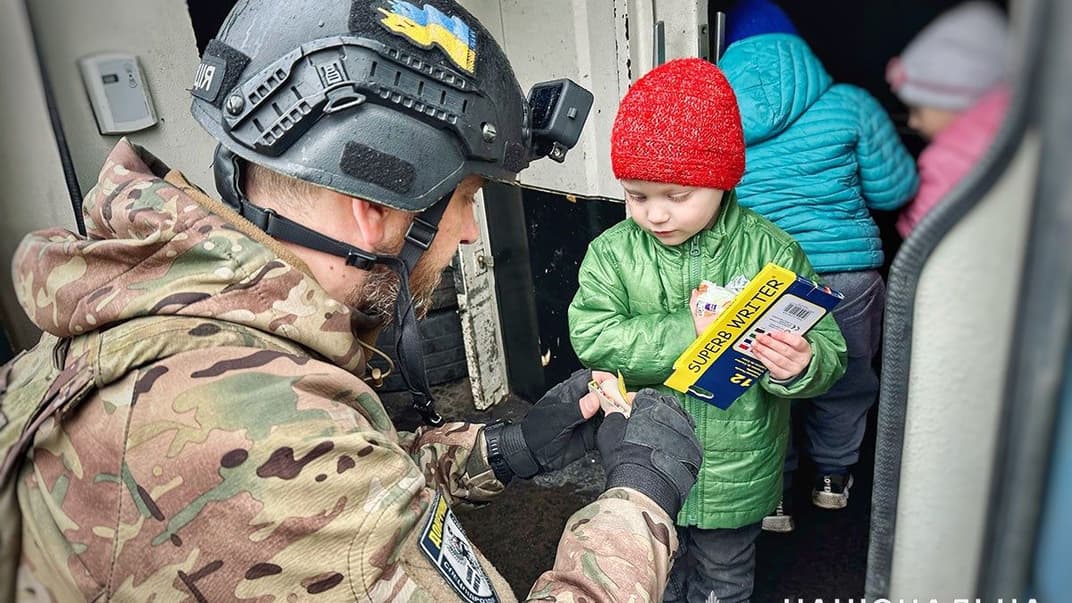 Полицейский вместе с детьми, вывезенными из Нью-Йорка