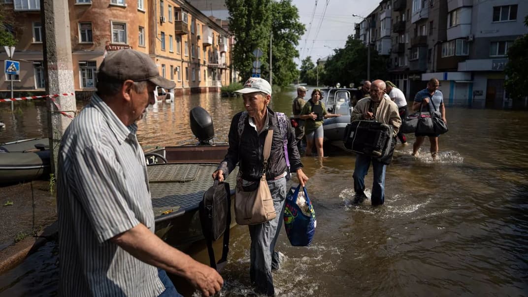 Женщина несет сумки после эвакуации из села Кардашинка на левом берегу реки Днепр в Херсоне, 9 июня 2023 года