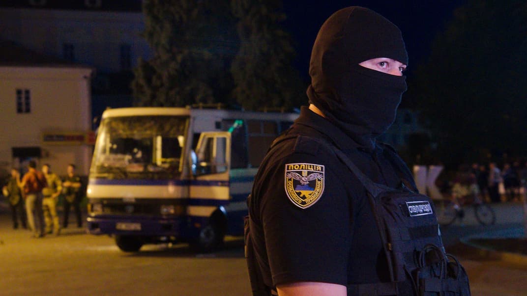 Поліцейський охороняє територію перед площею, на якій стоїть автобус, захоплений терористом