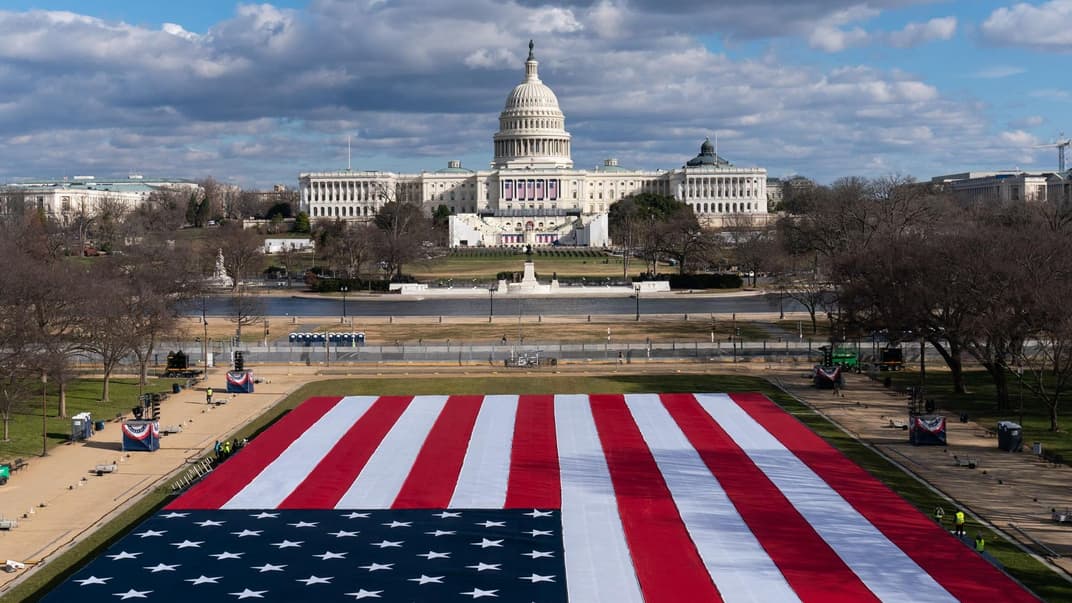 Большой американский флаг, размещенный на Национальном торговом центре позади Капитолия США перед инаугурацией избранного президента Джо Байдена и вице-президента Камалы Харрис, Вашингтон, 18 января 2021 года