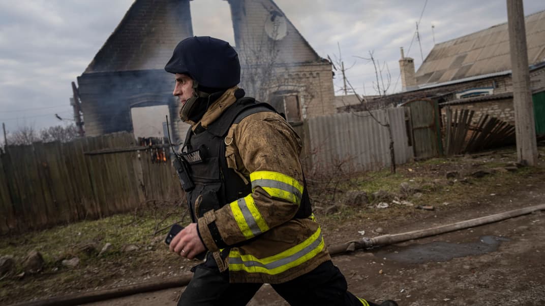 Рятувальник біжить, щоб сховатися після нових вибухів біля будинку, який обстріляли російські війська в Костянтинівці, 10 березня 2023 року