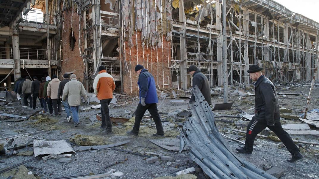 Украинские военнопленные идут к грузовику после уборки тел украинских военнослужащих из-под завалов здания Донецкого аэропорта, 25 февраля 2015 года. Бои за Донецкий аэропорт продолжались с сентября 2014-го до 22 января 2015 года. По данным Украинской источников, вследствие этих боев погибло около 100 украинских военных.