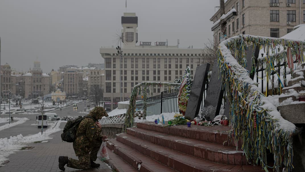 Український військовослужбовець стоїть на колінах перед меморіалом «Небесній сотні» в Києві, 21 листопада 2022 року