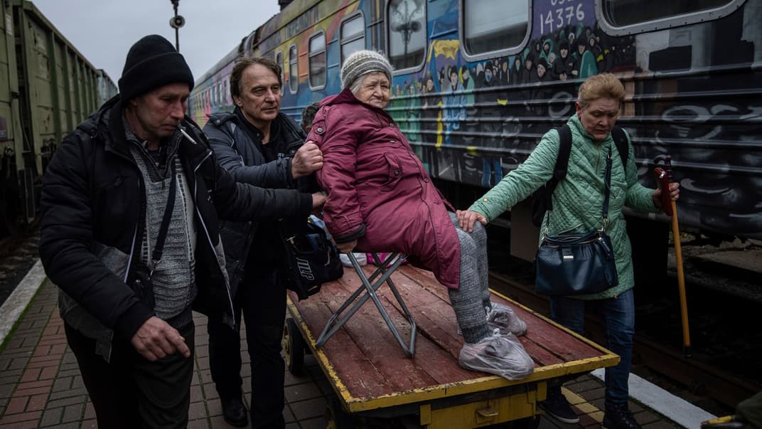 Родичі 94-річної Єлизавети везуть її на вантажному візку до евакуаційного поїзда в Херсоні, 1 грудня 2022 року