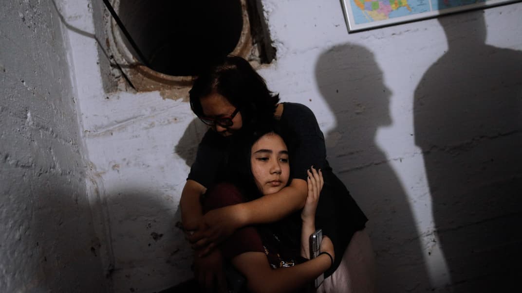 Люди прячутся в бомбоубежище от ракет, выпущенных из Сектора Газа. Их дом был разрушен ракетой за пару минут до этого. Рамат-Гана, центральный Израиль, 15 мая 2021 года