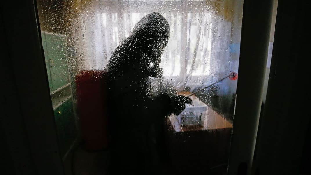 Работник экстренной службы самопровозглашенной Донецкой «ДНР» распыляет дезинфицирующее средство в больнице, где лечатся больные COVID-19, Донецк, Украина