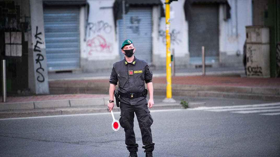 Офіцер поліції Guardia di Finanza в захисній масці для обличчя патрулює під час карантину в Мілані, Італія, 26 квітня 2020 року