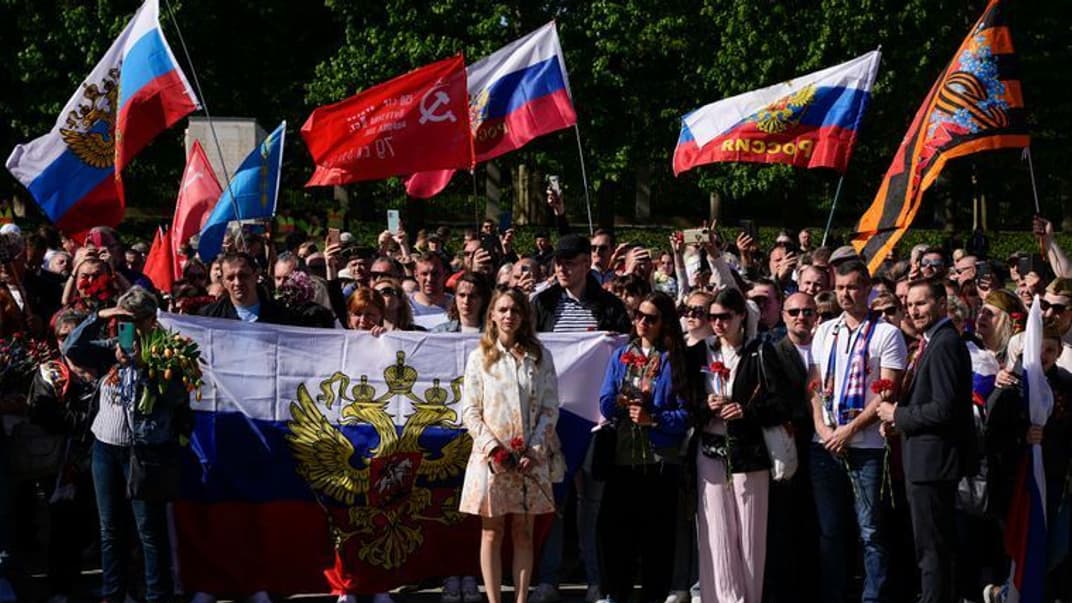 Люди с российскими и советскими флагами у советского военного мемориала в районе Трептов в Берлине, Германия, 9 мая 2022 года