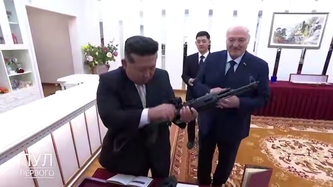 Глава Північної Кореї Кім Чени Ин тримає у руках автомат, подарований самопроголошеним президентом Білорусі Кім Чен Ином