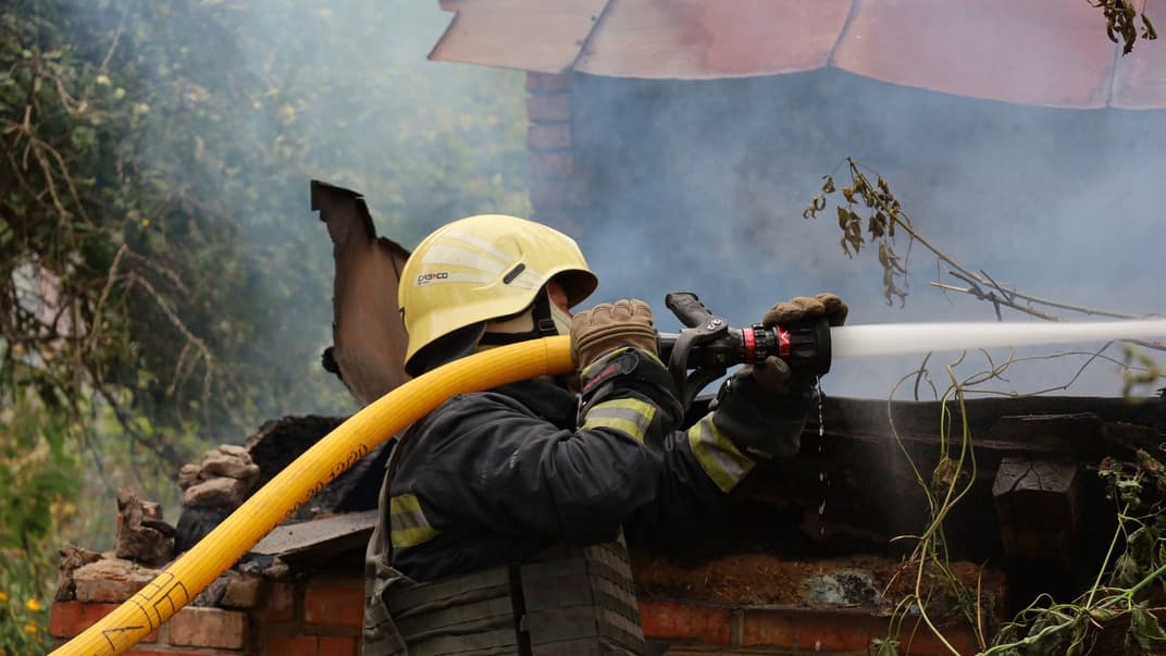Рятувальник гасить пожежу, яка виникла внаслідок російських обстрілів села Безруки на Харківщині, 3 вересня 2022 року