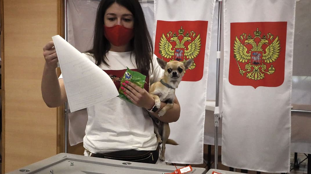 Женщина с собакой участвует в референдуме за поправки в Конституцию РФ на избирательном участке в Подольске недалеко от Москвы, Россия, 1 июля 2020 года