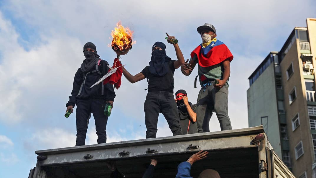 Учасники акції протесту проти президента Мадуро захопили вантажівку під часмасових заворшень у Каракасі, Венесуела, 23 січня 2019 року