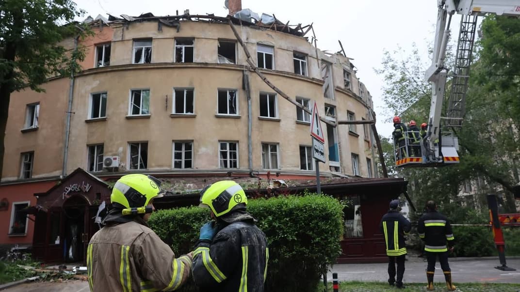 Спасатели перед зданием во Львове, которое пострадало в результате российских обстрелов 6 июля 2023 года