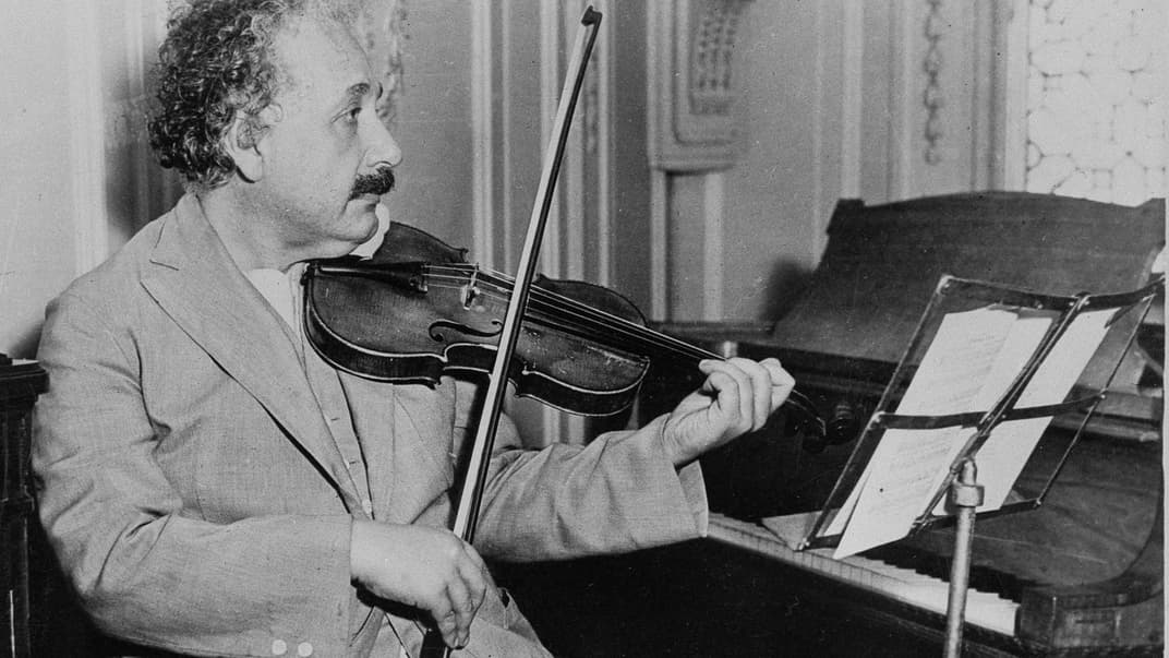 Альберт Айнштайн грає на скрипці, час і місце, де була зроблена фотографія, невідомі.