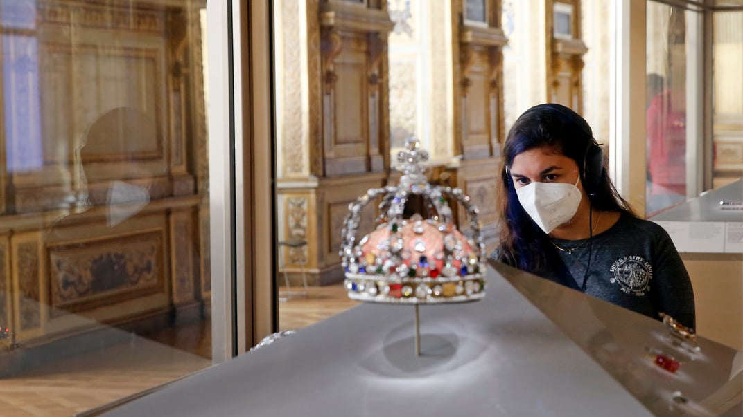 Ілюстративне фото. Відвідувачка розглядає корону французького короля Людовика XV, виставлену в галереї Аполлона в Луврі, 26 жовтня 2020 року в Парижі, Франція