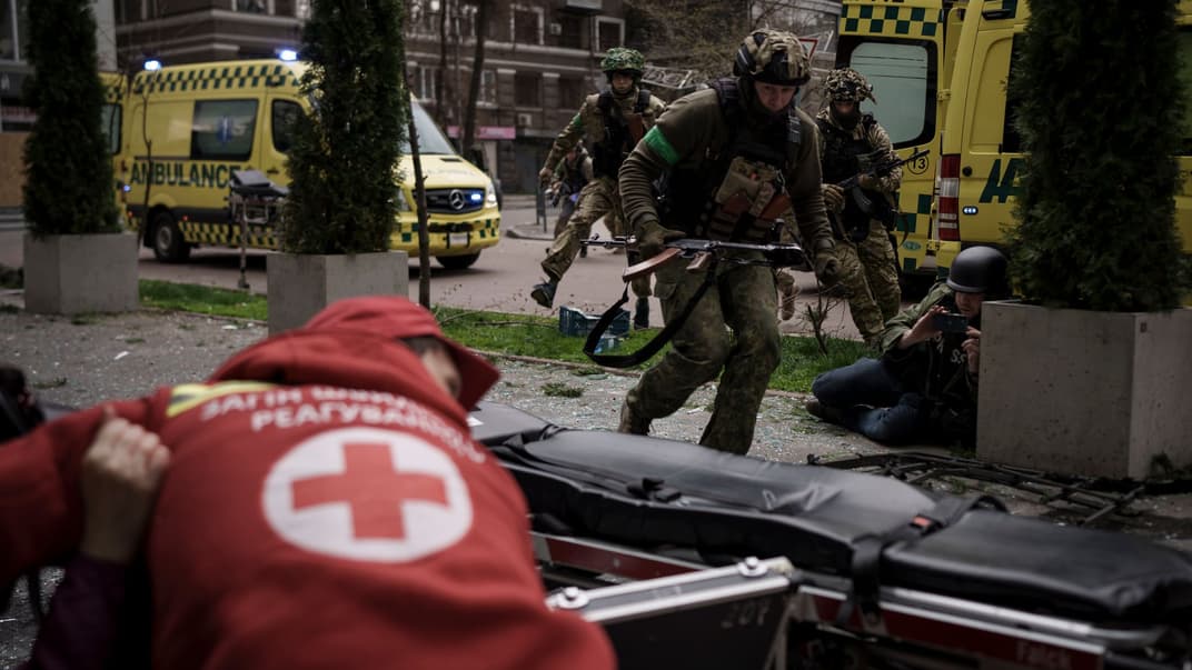 Українські військовослужбовці біжать в укриття під час обстрілу росією центру Харкова, 17 квітня 2022 року