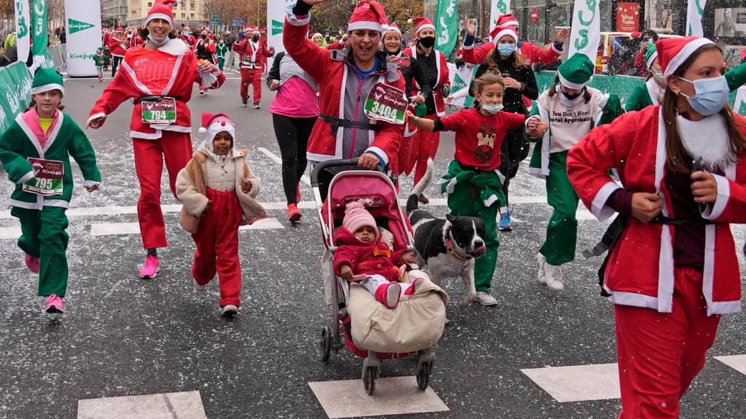 Люди у костюмах Санта-Клауса беруть участь у благодійному забігу в Мадриді, 19 грудня 2021 року