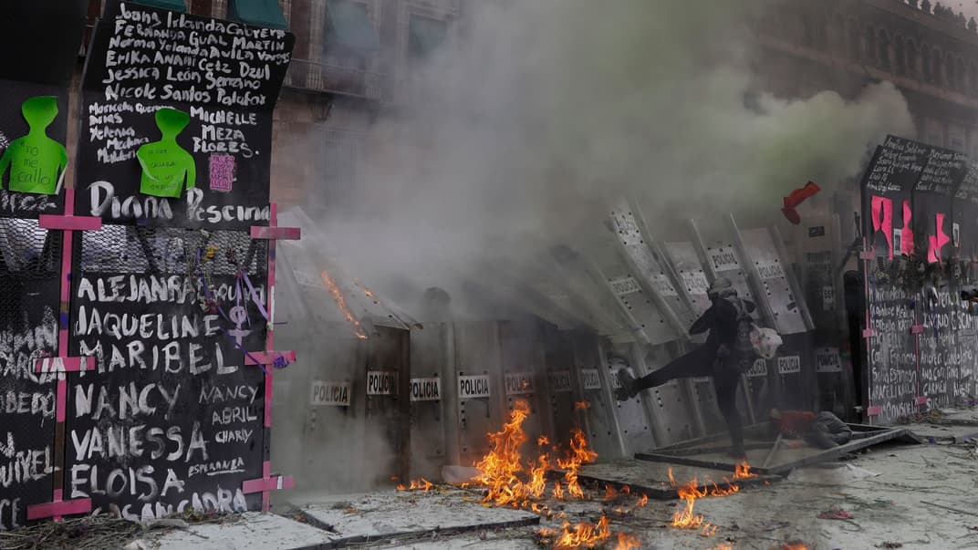 Демонстранти атакують поліцію, яка захищає президентський палац під час маршу з нагоди Міжнародного жіночого дня та протесту проти гендерного насильства у Мехіко, понеділок, 8 березня 2021 року
