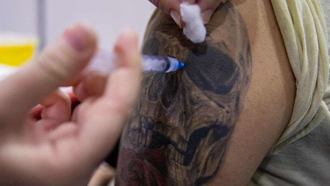 Медицинский работник готовится ввести студенту дозу вакцины CanSino против COVID-19 на участке вакцинации в кампусе Университета Андрес Белло в Сантьяго, Чили, 3 июня 2021 года